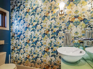 This stylish bathroom features a bold floral wallpaper that adds a vibrant touch to the space.