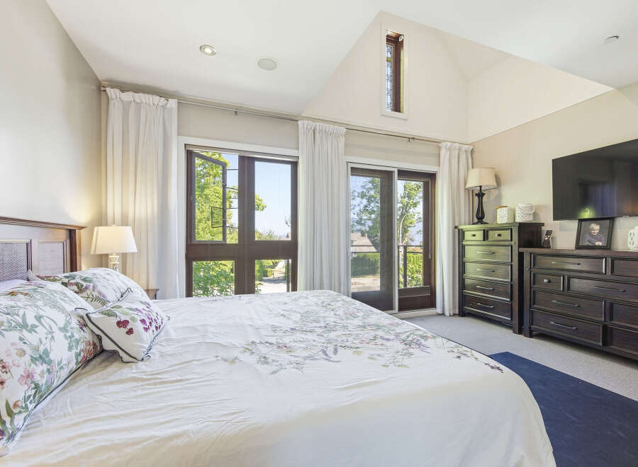 Experience luxury and comfort in this master bedroom, featuring a king-size bed with floral bedding and plush pillows.