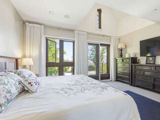 Experience luxury and comfort in this master bedroom, featuring a king-size bed with floral bedding and plush pillows.
