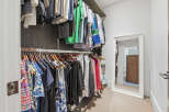 Step into this spacious walk-in closet, featuring ample hanging space for your wardrobe and a full-length mirror to complete your look.
