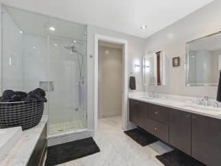 Experience luxury in this modern bathroom featuring a spacious glass-enclosed shower with sleek tilework.