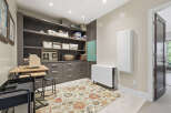 Discover this organized craft room featuring ample storage with floor-to-ceiling dark wood shelving and drawers.