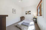 Discover this charming bedroom featuring a comfortable bed with soft linens and a cozy throw blanket.