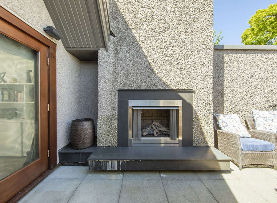 Enjoy outdoor living with this modern patio featuring a sleek gas fireplace, perfect for cozy evenings.