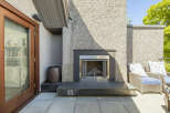 Enjoy outdoor living with this modern patio featuring a sleek gas fireplace, perfect for cozy evenings.