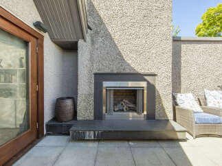 Enjoy outdoor living with this modern patio featuring a sleek gas fireplace, perfect for cozy evenings.