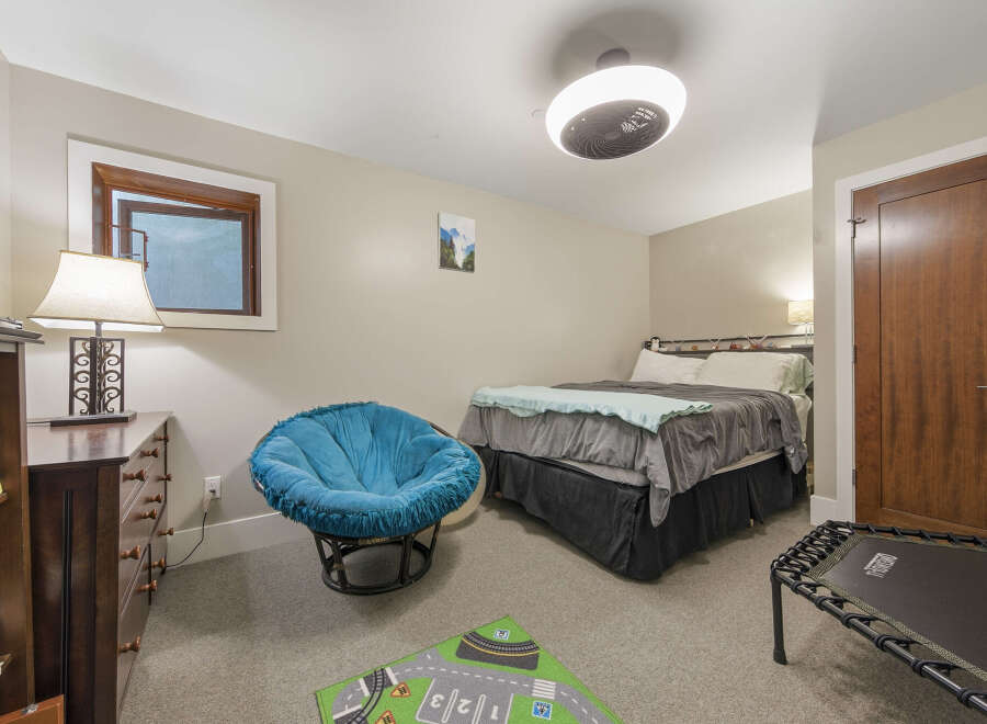 Discover comfort and style in this inviting bedroom, featuring a plush blue papasan chair perfect for relaxation.