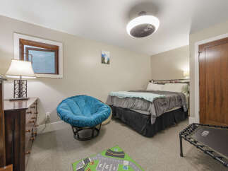 Discover comfort and style in this inviting bedroom, featuring a plush blue papasan chair perfect for relaxation.