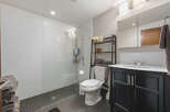 This modern bathroom features a spacious walk-in shower with white subway tile walls and a sleek glass enclosure.