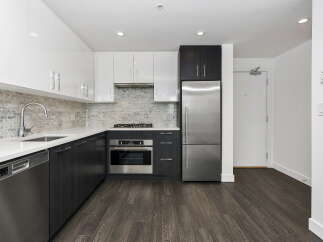 Experience modern living in this sleek kitchen featuring high-gloss white cabinetry and dark wood lower cabinets.