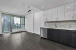 Experience modern living in this spacious apartment featuring a sleek kitchen with white cabinetry, a marble backsplash, and stainless steel appliances.