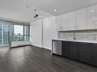 Experience modern living in this spacious apartment featuring a sleek kitchen with white cabinetry, a marble backsplash, and stainless steel appliances.