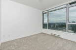 Experience breathtaking city views from this spacious room, featuring a wall-to-wall carpet and a large window that floods the space with natural light.