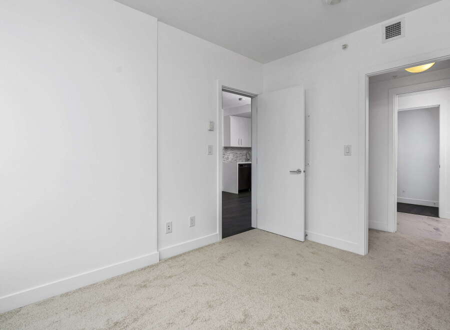 Step into this bright and airy living space, featuring plush carpeting and clean white walls for a modern aesthetic.