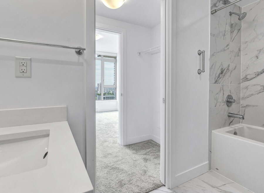 Experience modern luxury in this stunning bathroom featuring a sleek vanity with a built-in sink and a pristine white countertop.