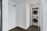 Discover modern convenience with this stacked LG washer and dryer set, neatly tucked away behind bi-fold doors.