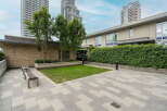 Enjoy outdoor living in this modern courtyard featuring a lush green lawn and stylish paved patio.