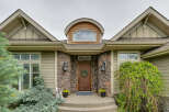 This charming home features a welcoming stone entryway leading to a beautiful wooden door adorned with a festive wreath.