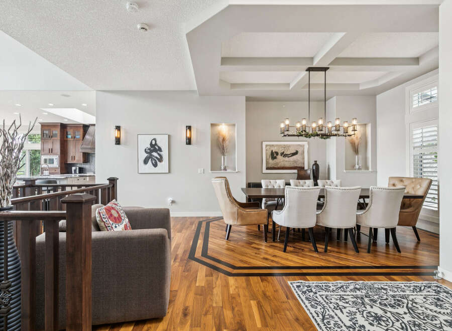Experience elegant dining in this spacious room featuring a large wooden table surrounded by upholstered chairs.