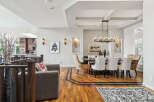 Experience elegant dining in this spacious room featuring a large wooden table surrounded by upholstered chairs.