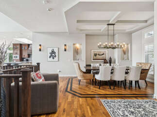 Experience elegant dining in this spacious room featuring a large wooden table surrounded by upholstered chairs.