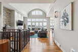 Experience luxury living in this stunning home featuring a grand, vaulted ceiling living area with a wall of windows overlooking the water.