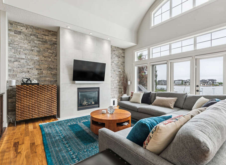 Experience luxury living in this stunning home featuring a modern living room with a stone accent wall and a sleek fireplace.