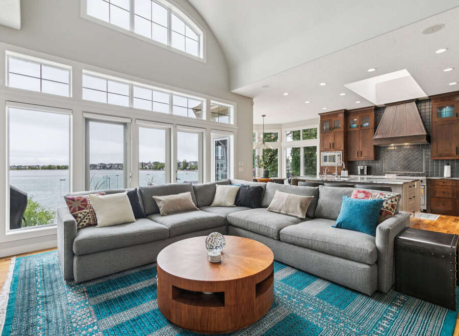 Experience luxury living with this stunning open-concept living space, featuring a massive sectional sofa perfect for entertaining and a beautiful wooden coffee table.