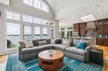 Experience luxury living with this stunning open-concept living space, featuring a massive sectional sofa perfect for entertaining and a beautiful wooden coffee table.