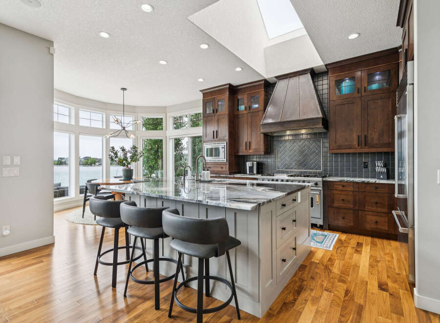 Experience luxury living in this stunning kitchen featuring a large island with a granite countertop, perfect for entertaining.