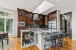 Experience luxury in this stunning kitchen featuring rich dark wood cabinetry, a dramatic copper range hood, and a spacious island with a unique marble countertop.