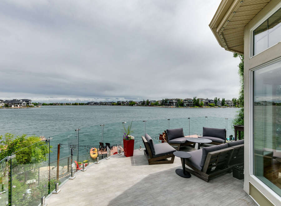 Enjoy breathtaking lake views from this stunning waterfront property's expansive deck, perfect for entertaining or relaxing.
