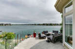Enjoy breathtaking lake views from this stunning waterfront property's expansive deck, perfect for entertaining or relaxing.