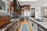 Experience culinary excellence in this stunning gourmet kitchen, featuring rich wood cabinetry, a professional-grade gas range, and a sleek stainless steel refrigerator.