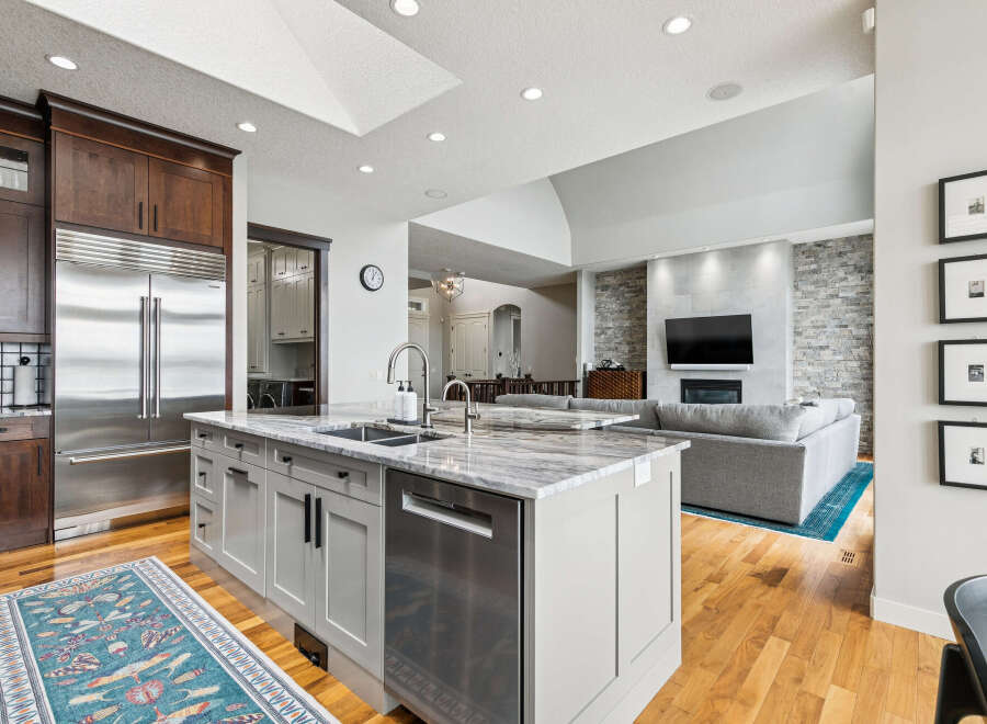 Experience luxury living in this stunning open-concept home, featuring a gourmet kitchen with a large island, sleek stainless steel appliances, and ample cabinet space.