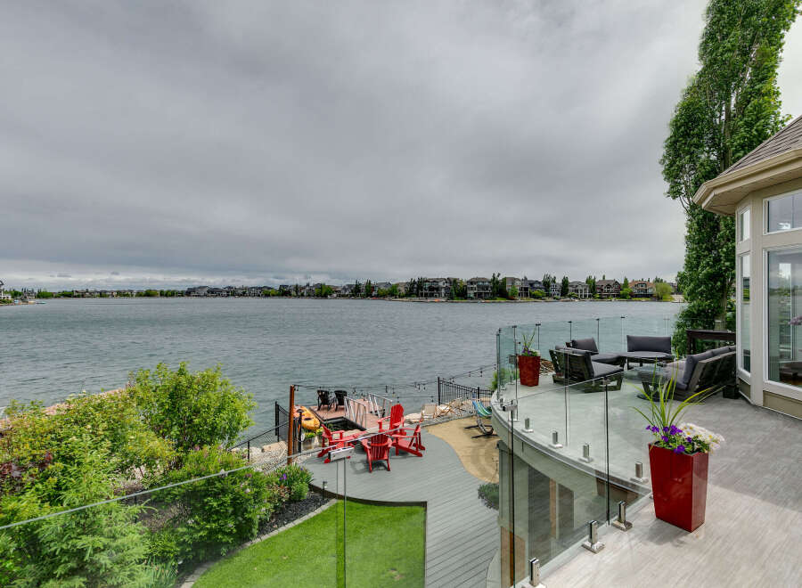 Experience luxurious waterfront living with this stunning property featuring a spacious deck overlooking a serene lake.