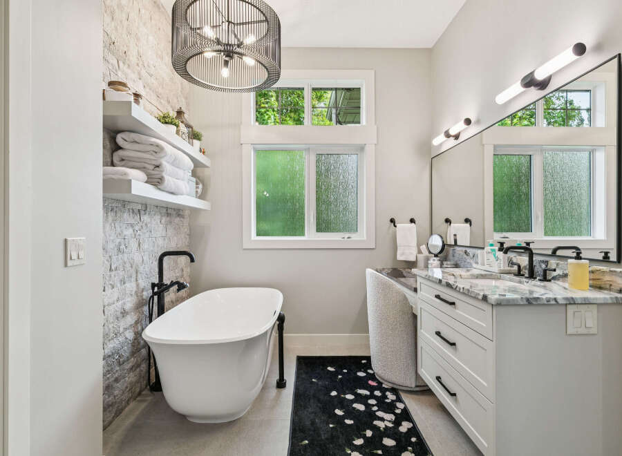 Indulge in luxury with this stunning bathroom featuring a freestanding soaking tub, perfect for unwinding after a long day.