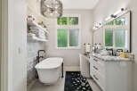 Indulge in luxury with this stunning bathroom featuring a freestanding soaking tub, perfect for unwinding after a long day.