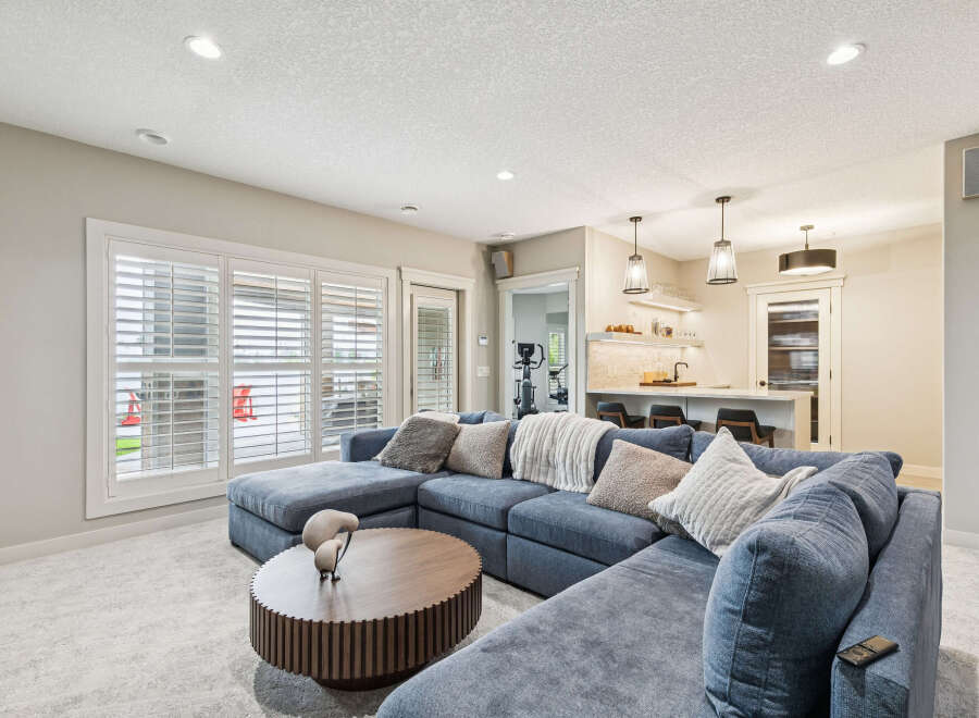 Experience ultimate relaxation in this spacious living area, featuring a plush, deep-blue sectional sofa perfect for family gatherings.