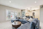 Experience ultimate relaxation in this spacious living area, featuring a plush, deep-blue sectional sofa perfect for family gatherings.