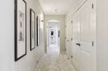 Step into this elegant hallway featuring a plush, neutral carpet and sophisticated wall sconces that cast a warm glow.
