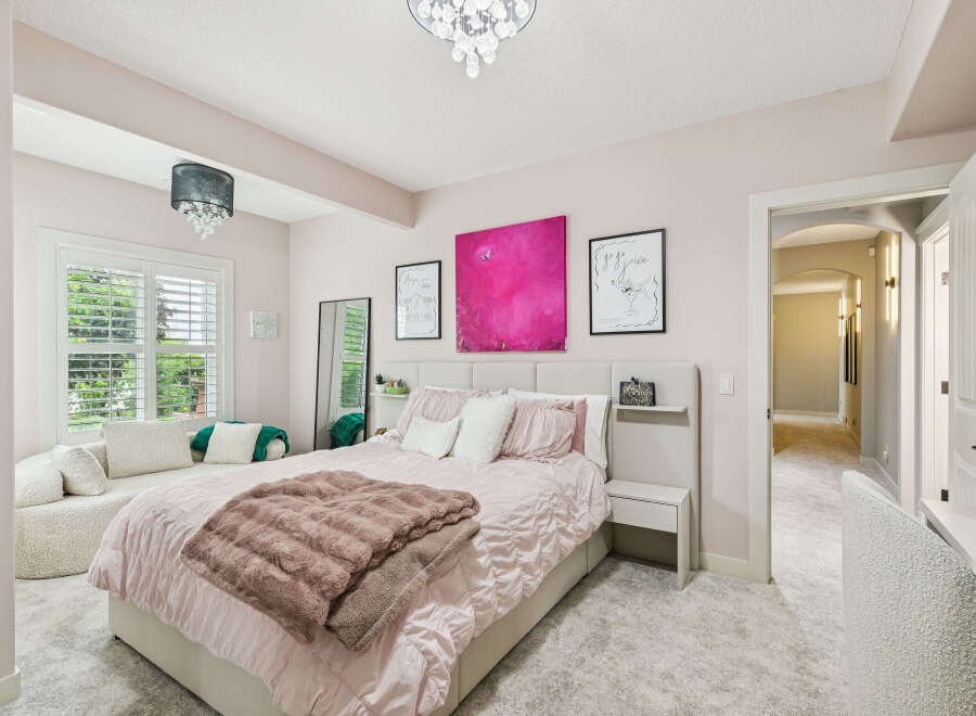 Experience luxury and comfort in this beautifully appointed bedroom, featuring a plush king-sized bed adorned with soft pink linens and a cozy faux fur throw.