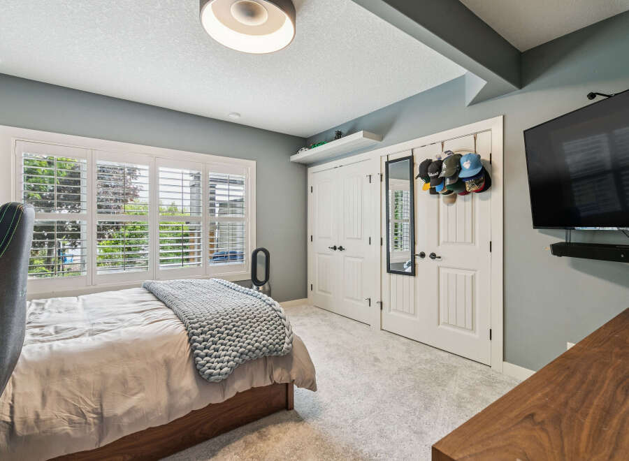 This bedroom features a comfortable bed with a chunky knit throw, perfect for relaxation.