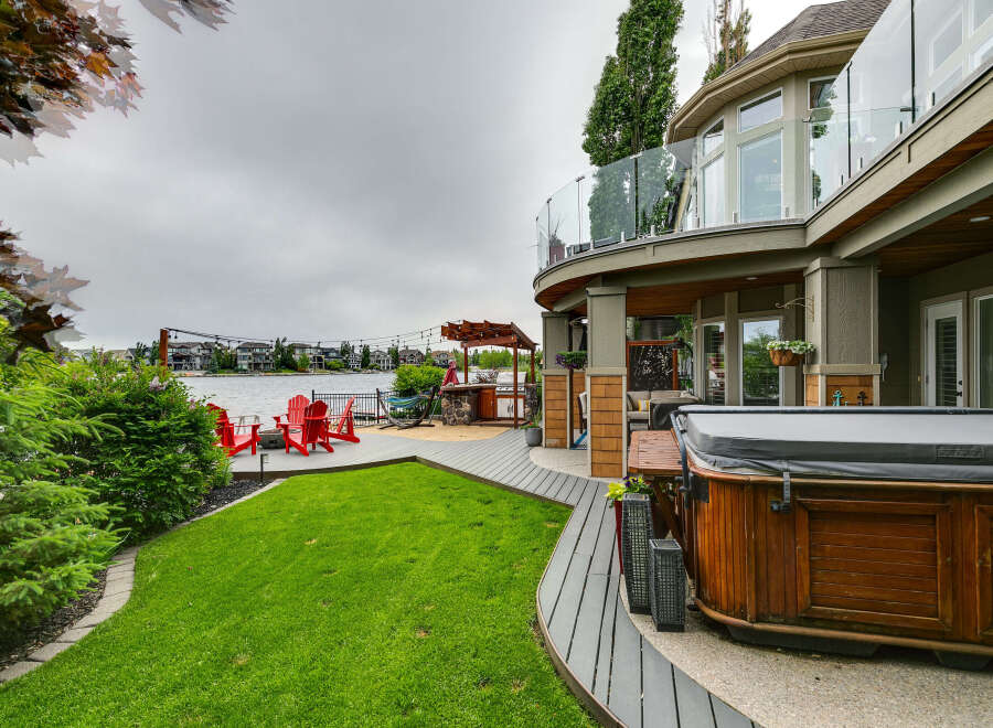 Experience luxurious waterfront living with this stunning property featuring a spacious deck, a relaxing hot tub, and a private dock perfect for enjoying lake activities.