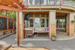 Enjoy outdoor living with this covered patio featuring a sectional sofa, coffee table, and string lights.