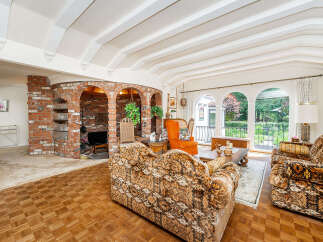 Step into this charming living room featuring a unique brick fireplace with arched openings and built-in shelving.