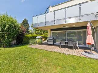Enjoy outdoor living with this spacious backyard featuring a wooden deck, perfect for entertaining.