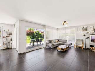Experience modern living in this spacious living room featuring a comfortable sectional sofa and a stylish coffee table.