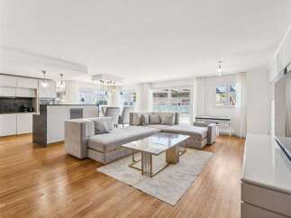 Experience modern living in this spacious open-concept apartment, featuring a sleek, contemporary kitchen with ample cabinetry and a large island.