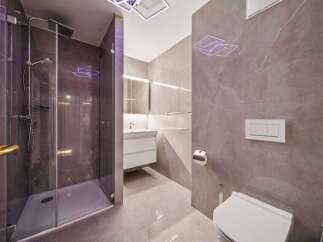 Experience modern luxury in this stunning bathroom featuring a sleek glass-enclosed shower with a rainfall showerhead.